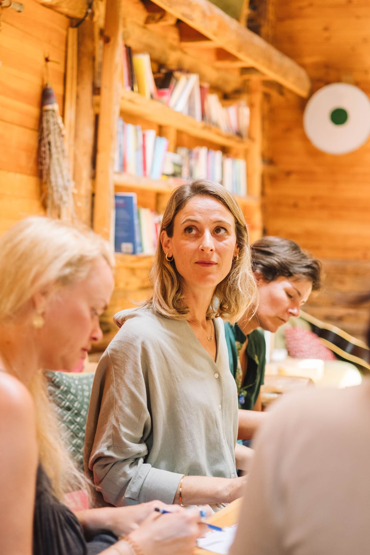 A group gathered for a reading session in a wood-panelled cabin